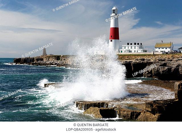 England, Dorset, Portland Bill, Waves breaking over rocks by Portland Bill lighthouse