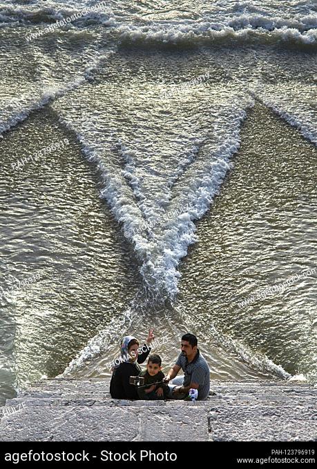 A family sits on the Khadju Bridge across the Zayandeh Rud River in the Iranian city of Isfahan, taken on April 25, 2017