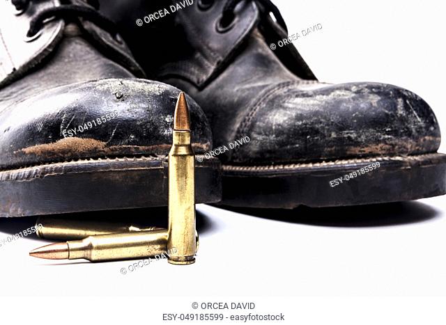Army boots and bullets isolated on white background with shadow