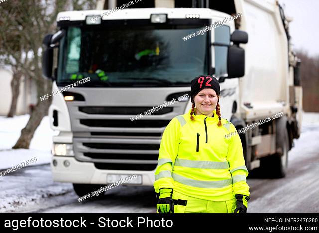 Woman standing in front of garbage truck