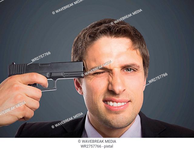 Close up of business man with gun to head against grey background