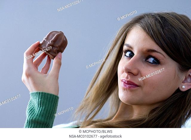 young woman with a chocolate marsmallow in her hand