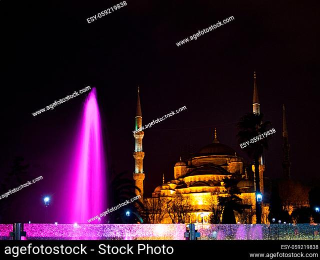 Ein bunter Springbrunnen vor einer beleuchteten Moschee in Istanbul