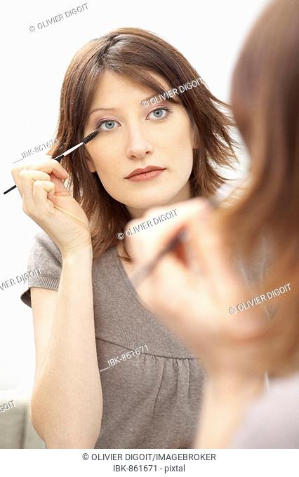 Portrait of a woman applying mascara