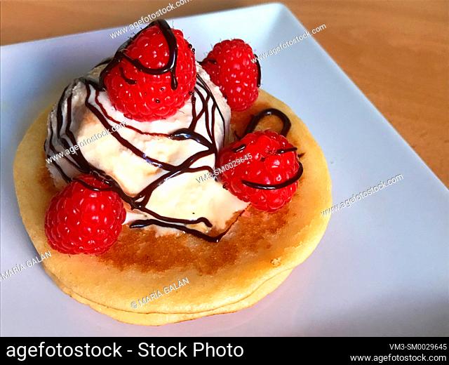 Pancakes with ice cream, raspberries and chocolate syrup