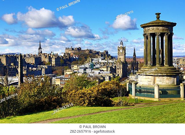 General city skyline view from Calton Hill showing the Dugald Stewart Monument and Edinburgh Castle in Edinburgh, Scotland, United Kingdom