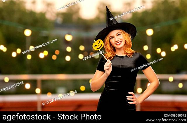 woman in halloween costume of witch with pumpkin