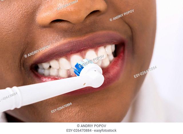 Close-up Of A Woman Brushing Teeth With Electric Toothbrush