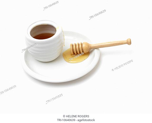 Honey In Honey Pot On A Plate And Wooden Honey Dipper