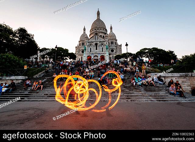 PARIS - JULY 1: Fire Show in front of Sacre Coeur Cathedral in Paris on July 1, 2013. The Sacre Coeur Basilica was designed by Paul Abadie