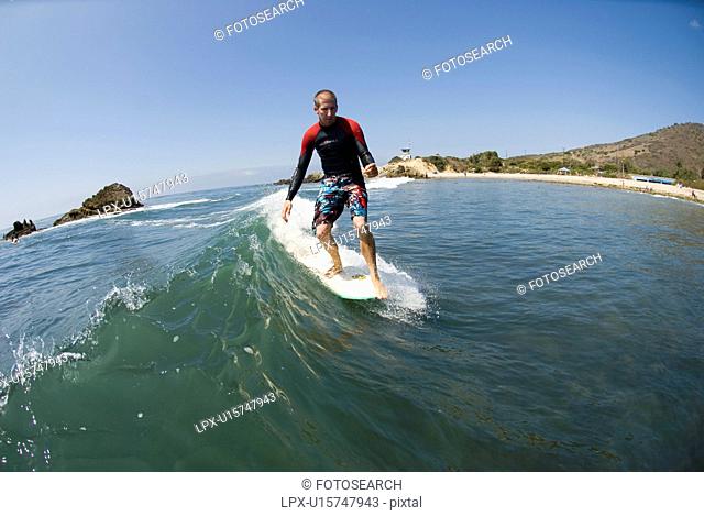 A surfer hanging five at Leo Carrillo State Beach California USA