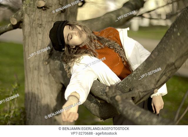 young woman leaning on tree, nature, relaxed, exhausted, in city Cottbus, Brandenburg, Germany