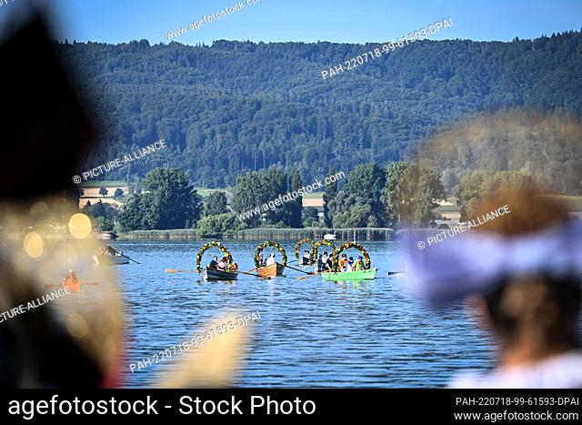 18 July 2022, Baden-Wuerttemberg, Radolfzell am Bodensee: Boats decorated with flower wreaths sail across Lake Constance to the shore of Radolfzell during the...