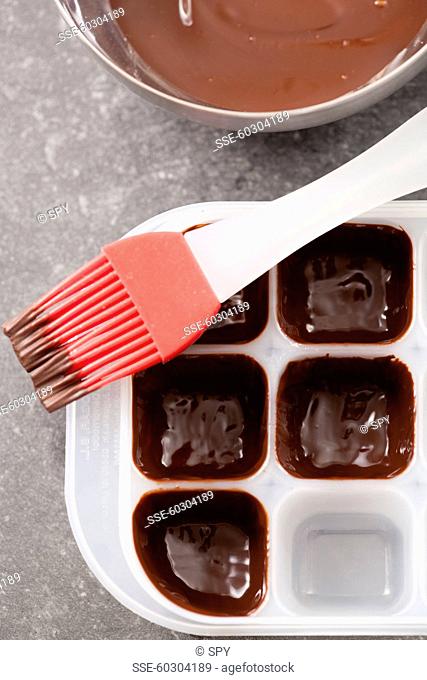 Coating the mould with melted chocolate by using a brush