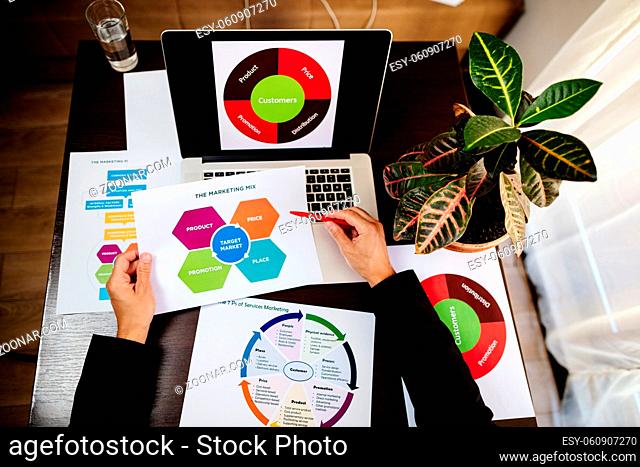 marketing product manager holding marketing promotion plan marketing product manager desk. Marketing mix plan for target market