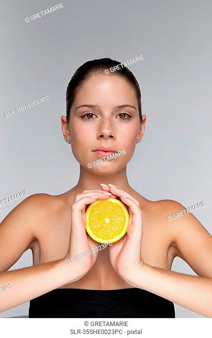 Woman holding halved orange