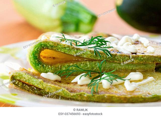 fried zucchini with mayo and dill on a plate