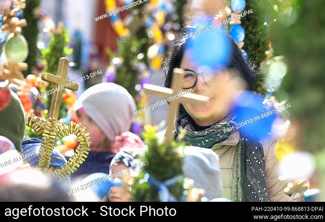 10 April 2022, Baden-Wuerttemberg, Bad Saulgau: A woman takes part in the Palm Sunday procession. For Christians, this day marks the beginning of Holy Week