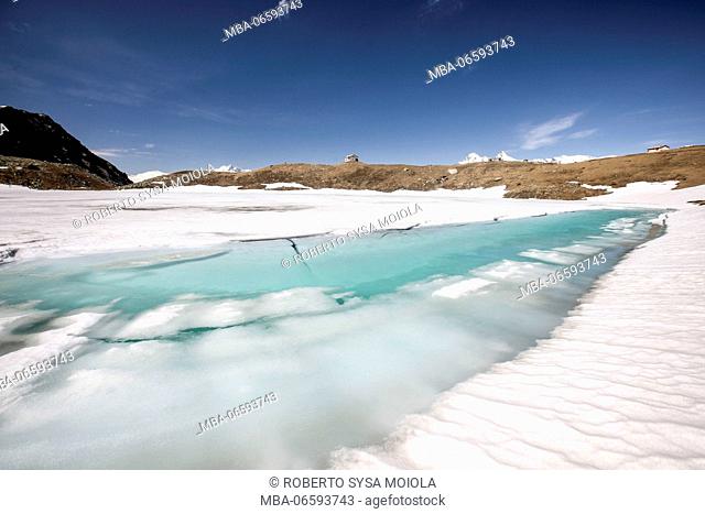 Turquoise water and snow at lake Emet during the thaw Madesimo Chiavenna Valley Valtellina Lombardy Italy Europe