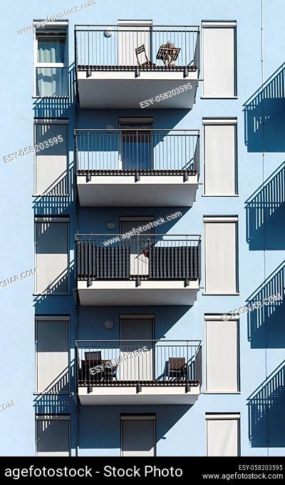 Blue new building with shutters and balconies in sunshine
