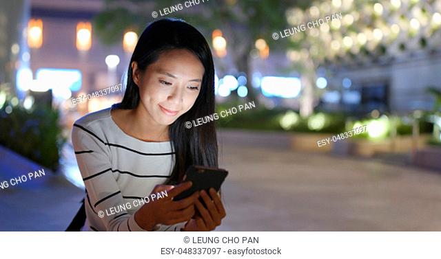 Woman use of smart phone at outdoor night