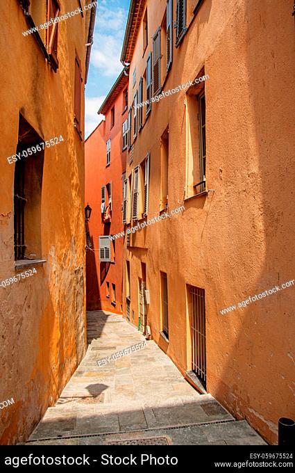 View of narrow alley and buildings with shops in the city center of Grasse, known for producing perfumes. Located in the Alpes-Maritimes department