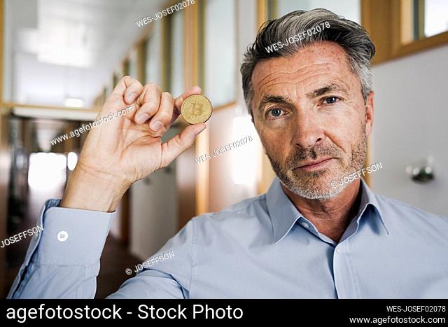 Businessman holding bitcoin in hand at office