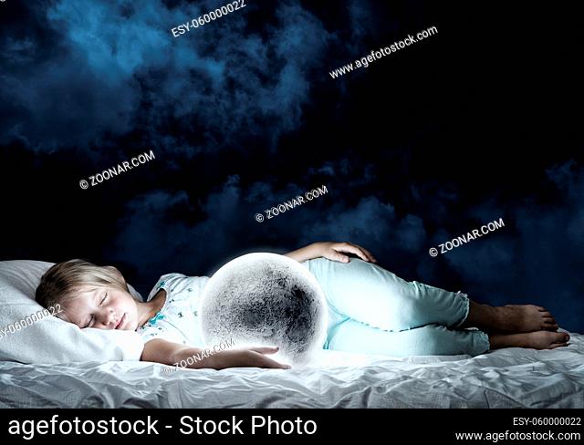 Cute girl sitting in bed and looking at moon planet