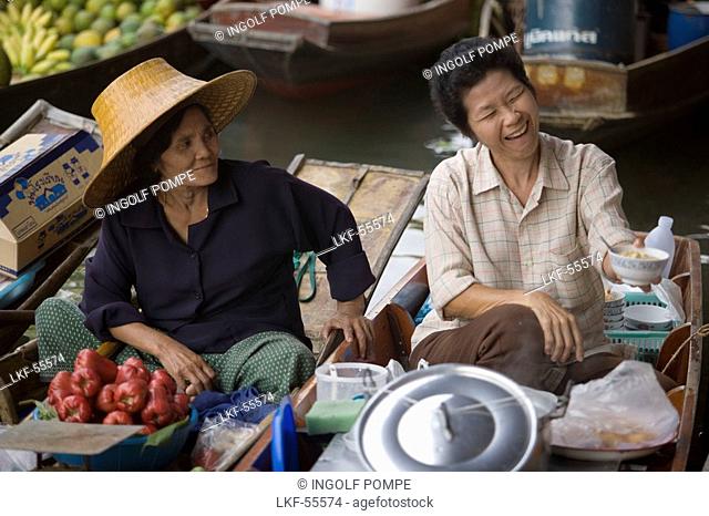 Laughing market-woman holding a dish, another watching her, Floating Market, Damnoen Saduak, near Bangkok, Ratchaburi, Thailand
