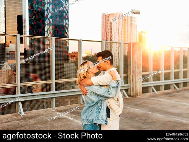 happy young couple on roof top city parking