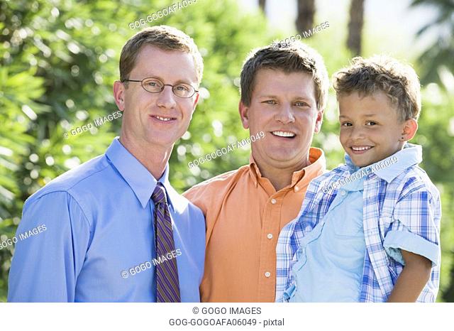 Gay couple smiling with their son