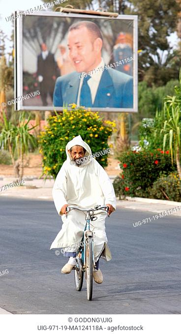 Cyclist and portrait of king Mohammed VI , Taroudan, Morocco
