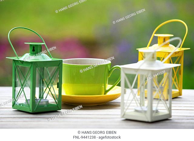 Garden table with coffee cups and table lantern