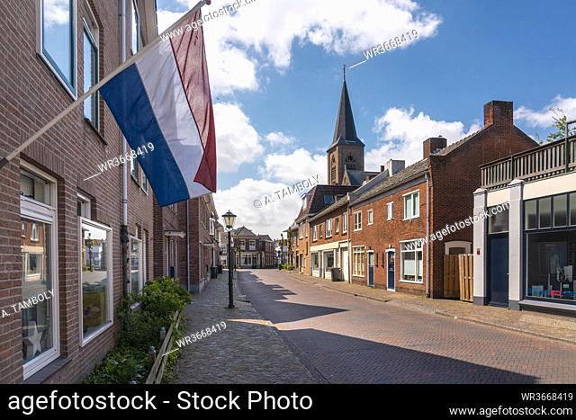 Netherlands, South Holland, Noordwijk, Dutch flag fluttering over empty town street