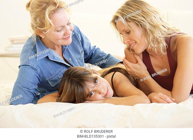 Three generations of women laying on bed