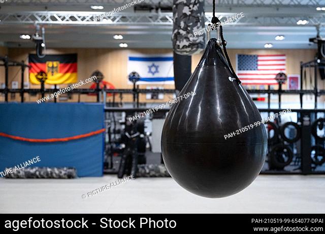 10 May 2021, Baden-Wuerttemberg, Calw: A punching bag is seen in front of a German, an Israeli and a US-American flag in the close combat training room of the...