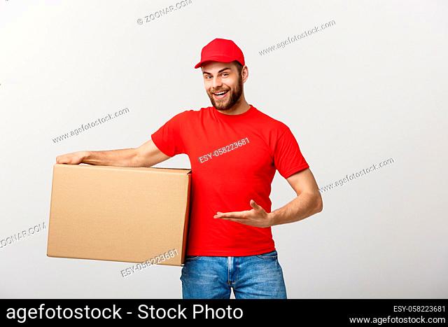 Delivery Concept - Portrait of Happy Caucasian delivery man pointing hand to present a box package. Isolated on Grey studio Background. Copy Space