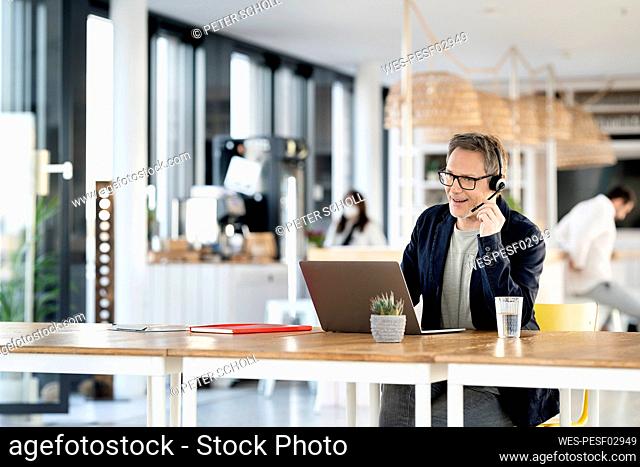 Male customer service representative talking through headset at cafeteria