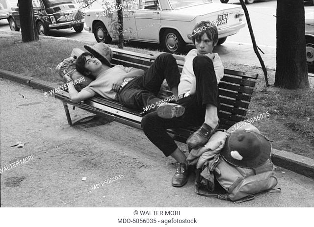 Young tourists relaxing on a bench on August 15th in Milan. Milan, 15th August 1968