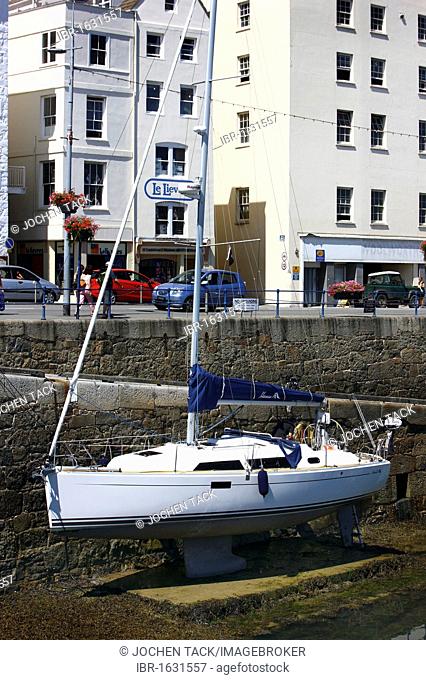 Boat lying dry in the marina at low tide, main port, St. Peter Port, Guernsey, Channel Islands, Europe