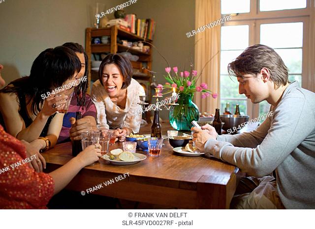 Friends laughing at dinner table