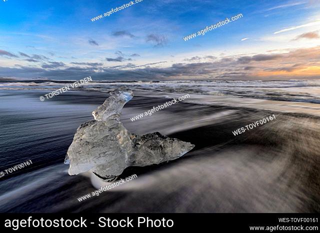 Iceland, Ice chunk lying at shore of¶ÿJokulsarlon¶ÿat dusk