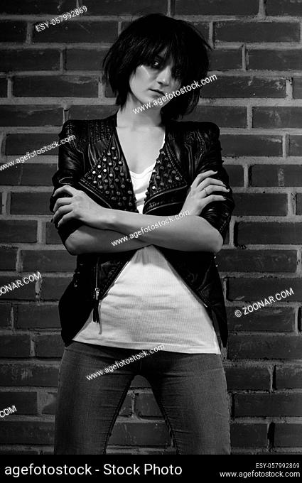 Androgyny female model in Heroin chic style near brick wall. Old style tinted image