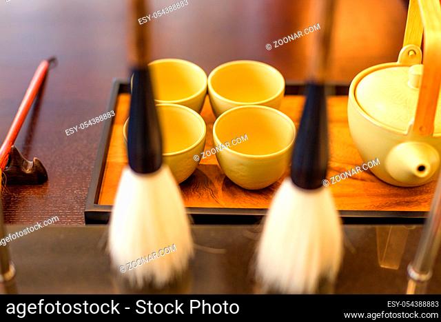 elegance tea set and calligraphy brush on table in modern study