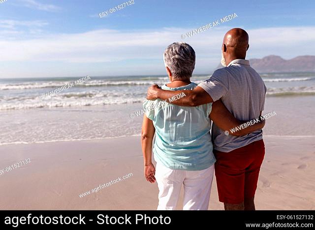 Rear view of senior african american couple hugging each other on the beach