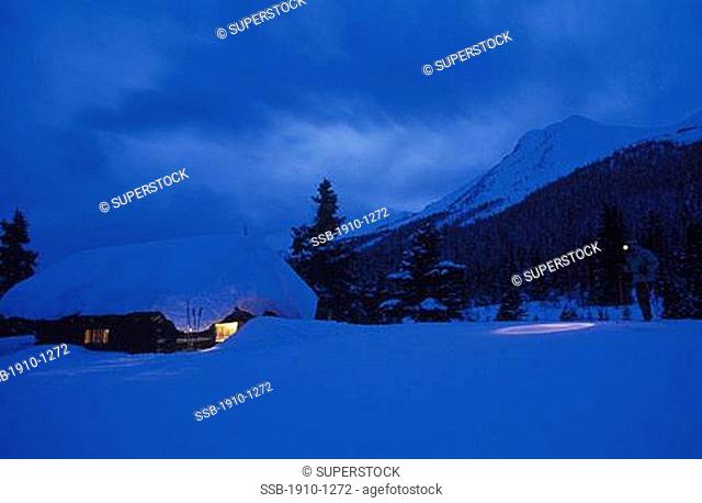 Skier approaching Half-way hut in winter Skoki Valley Banff Natl Park CANADA Alberta