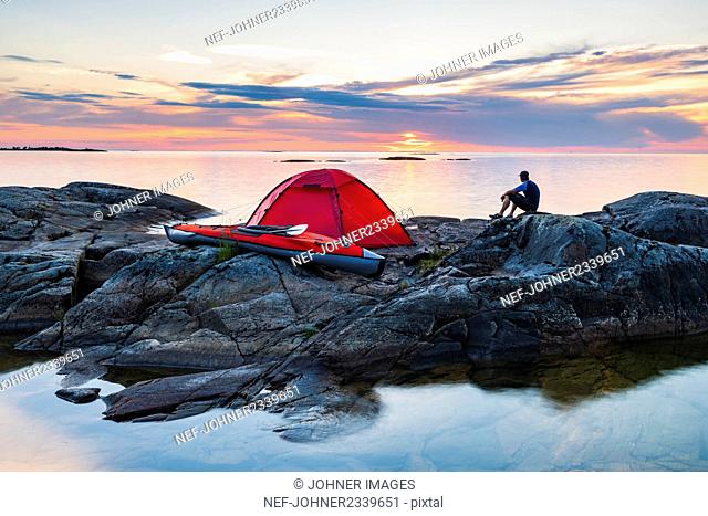 Man sitting on rocks by tent