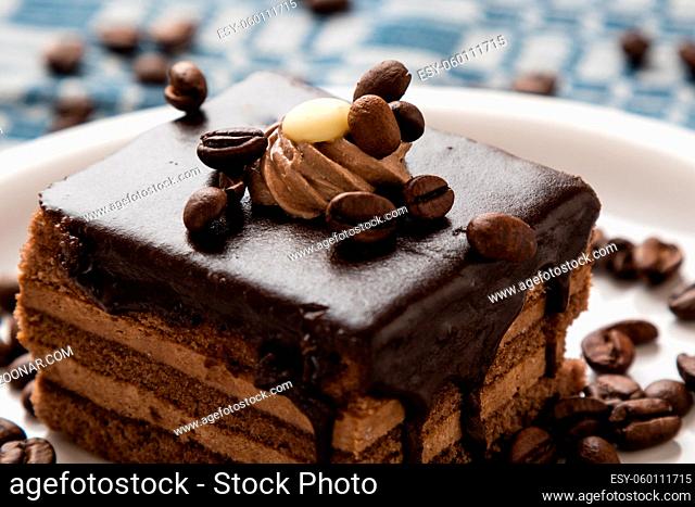 chocolate cake and coffee beans on white plate