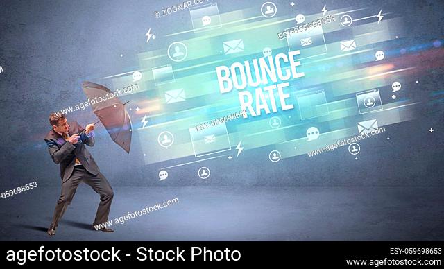 Handsome businessman defending with umbrella from BOUNCE RATE inscription, new age media concept