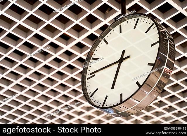 Modern clock with dial on structured wall background